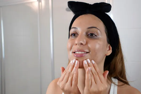 Młoda kobieta zaaplikowała krem na bazie skwalanu na twarz 